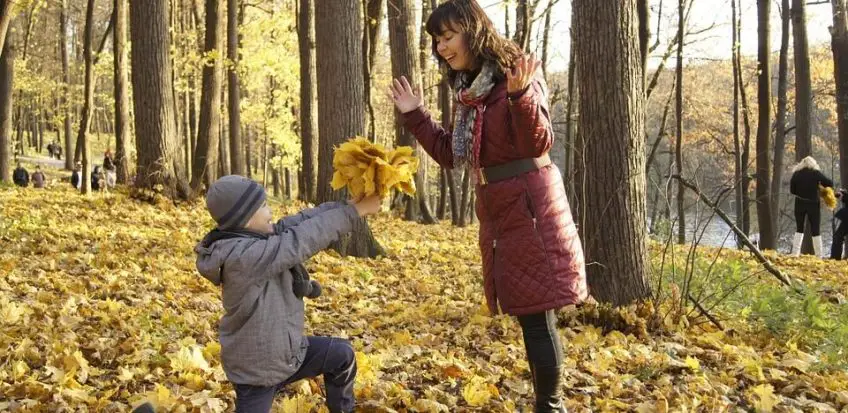 Kind schenkt einer Frau einen Blumenstrauß. Das Abschiedsgeschenk für eine Tagesmutter